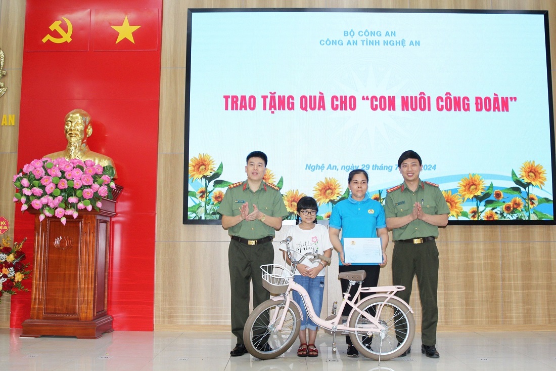 Đồng chí Đại tá Trần Hồng Quang, Phó Giám đốc Công an tỉnh và đại diện Ban Công đoàn trao tặng quà và Giấy chứng nhận cho “Con nuôi Công đoàn” do Công đoàn Công an tỉnh đảm nhận, hỗ trợ