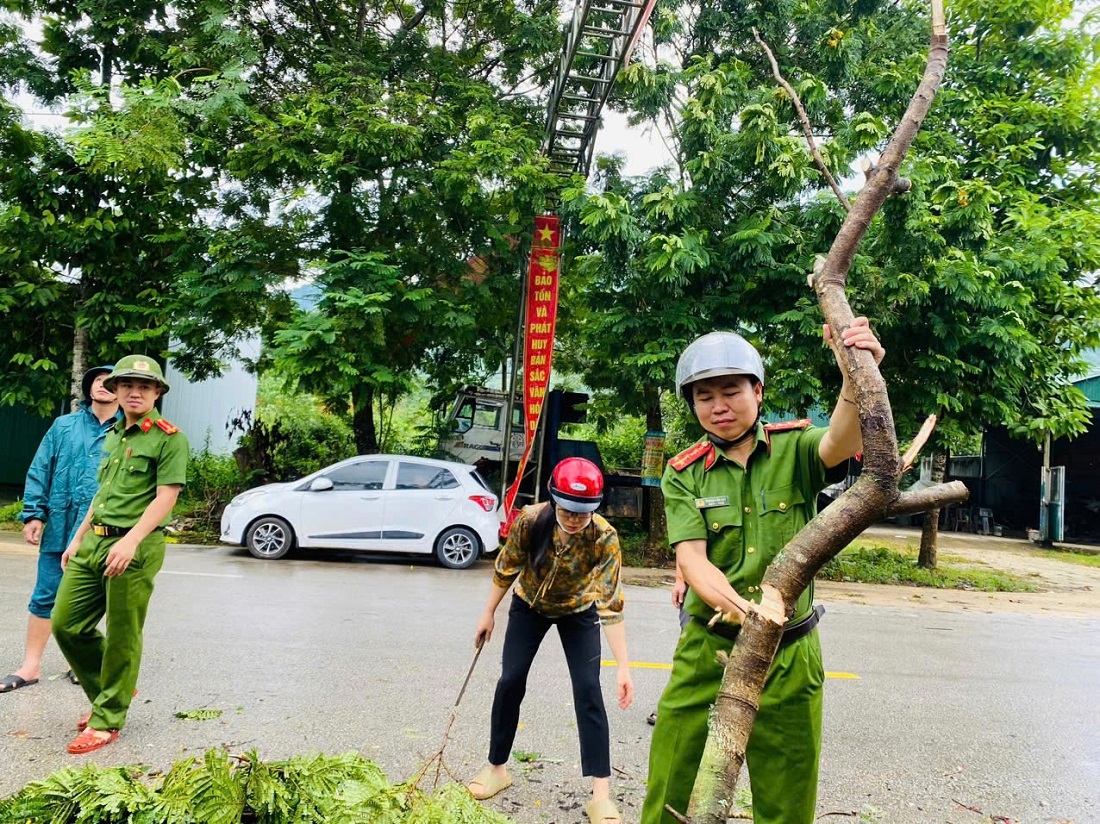 Công an huyện Quế Phong phối hợp với các lực lượng chức năng giúp người dân dọn dẹp cây cối và sửa lại nhà bị tốc mái