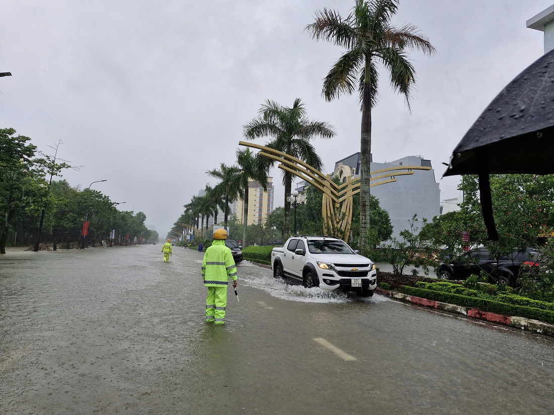 Đội CSGT - TT Công an thành phố Vinh phân luồng, điều tiết phương tiện, hướng dẫn, cảnh báo người dân và các phương tiện không đi vào chỗ nước sâu, đảm bảo an toàn cho người tham gia giao thông… 