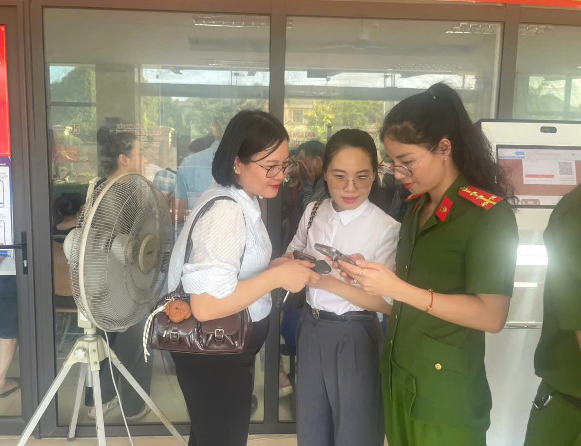 Cán bộ Phòng Cảnh sát QLHC về TTXH hướng dẫn người dân thực hành thao tác tham gia ý kiến qua ứng dụng VNeID