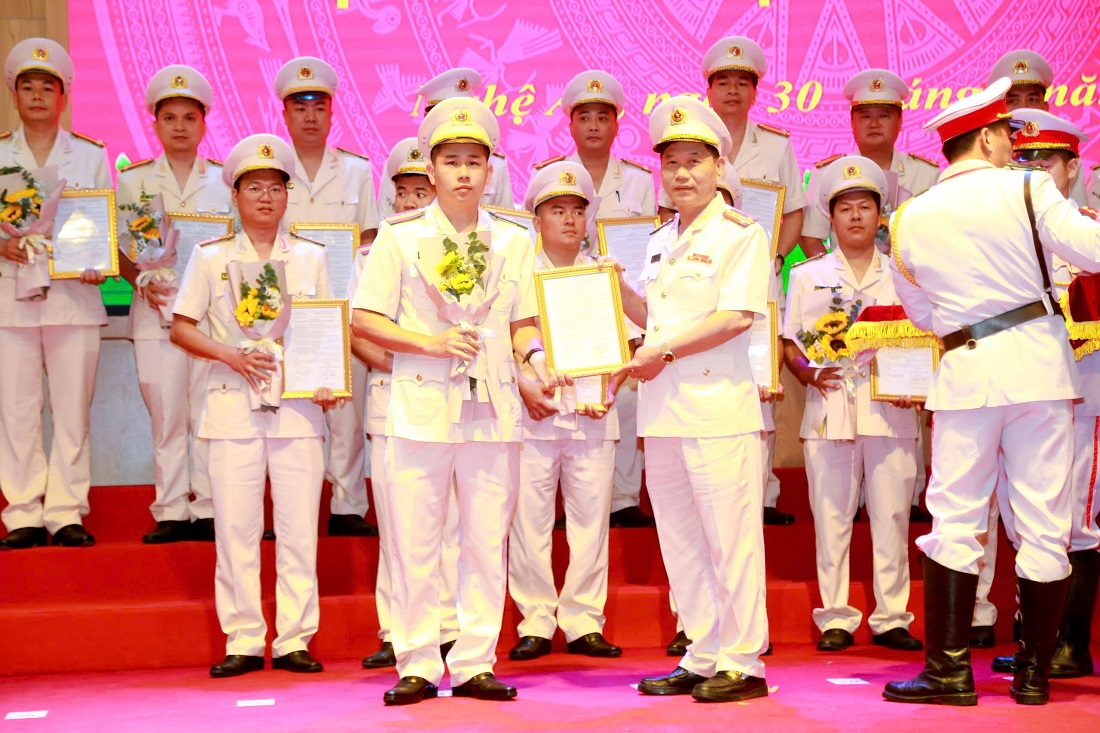 Đồng chí Đại tá Lê Văn Thái, Phó Giám đốc Công an tỉnh trao quyết định, tặng hoa chúc mừng các đồng chí thăng cấp bậc hàm và nâng lương