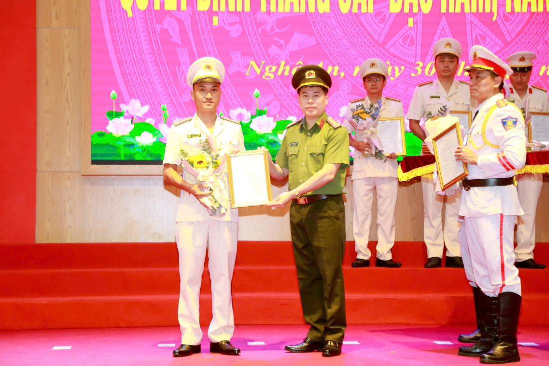 Đồng chí Đại tá Trần Hồng Quang, Phó Giám đốc Công an tỉnh trao quyết định, tặng hoa chúc mừngcác đồng chí thăng cấp bậc hàm và nâng lương