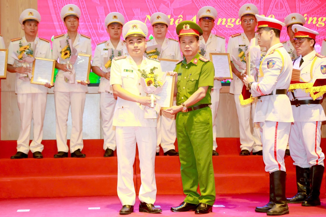 Đồng chí Đại tá Nguyễn Duy Thanh, Phó Giám đốc Công an tỉnh trao quyết định, tặng hoa chúc mừng các đồng chí thăng cấp bậc hàm và nâng lương