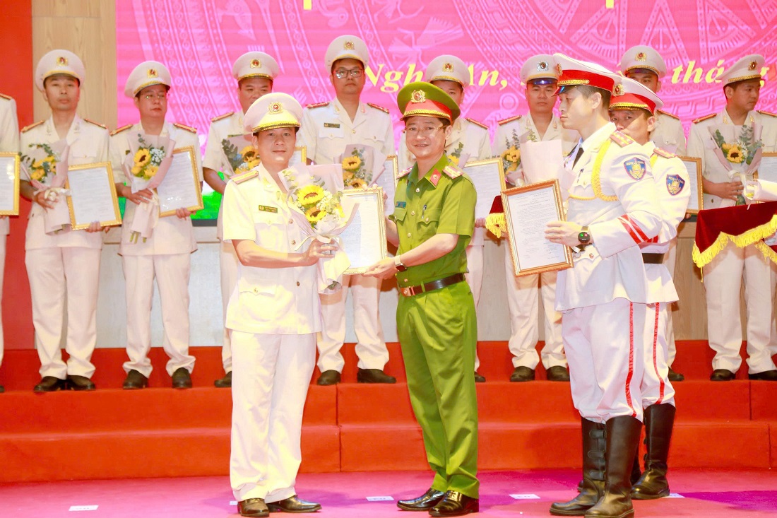 Đồng chí Đại tá Trần Ngọc Tuấn, Phó Giám đốc Công an tỉnh trao quyết định, tặng hoa chúc mừngcác đồng chí thăng cấp bậc hàm và nâng lương