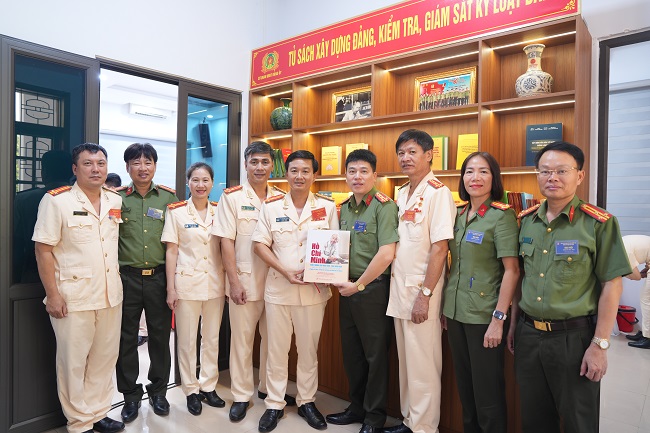 Các đại biểu tham quan, chụp ảnh lưu niệm tại tủ sách vừa mới xây dựng của đơn vị