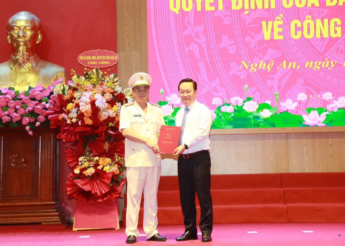 Đồng chí Nguyễn Đức Trung, Bí thư Tỉnh ủy trao quyết định của Ban Thường vụ Tỉnh ủy và tặng hoa chúc mừng đồng chí Đại tá Đinh Việt Dũng, tân Bí thư Đảng ủy, Giám đốc Công an tỉnh