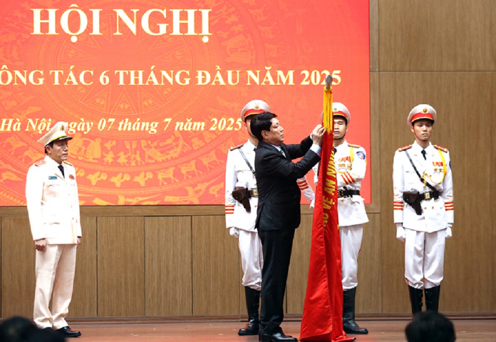 Chủ tịch nước Lương Cường gắn Huân chương Lao động hạng Ba lên Cờ truyền thống của Bộ Công an.