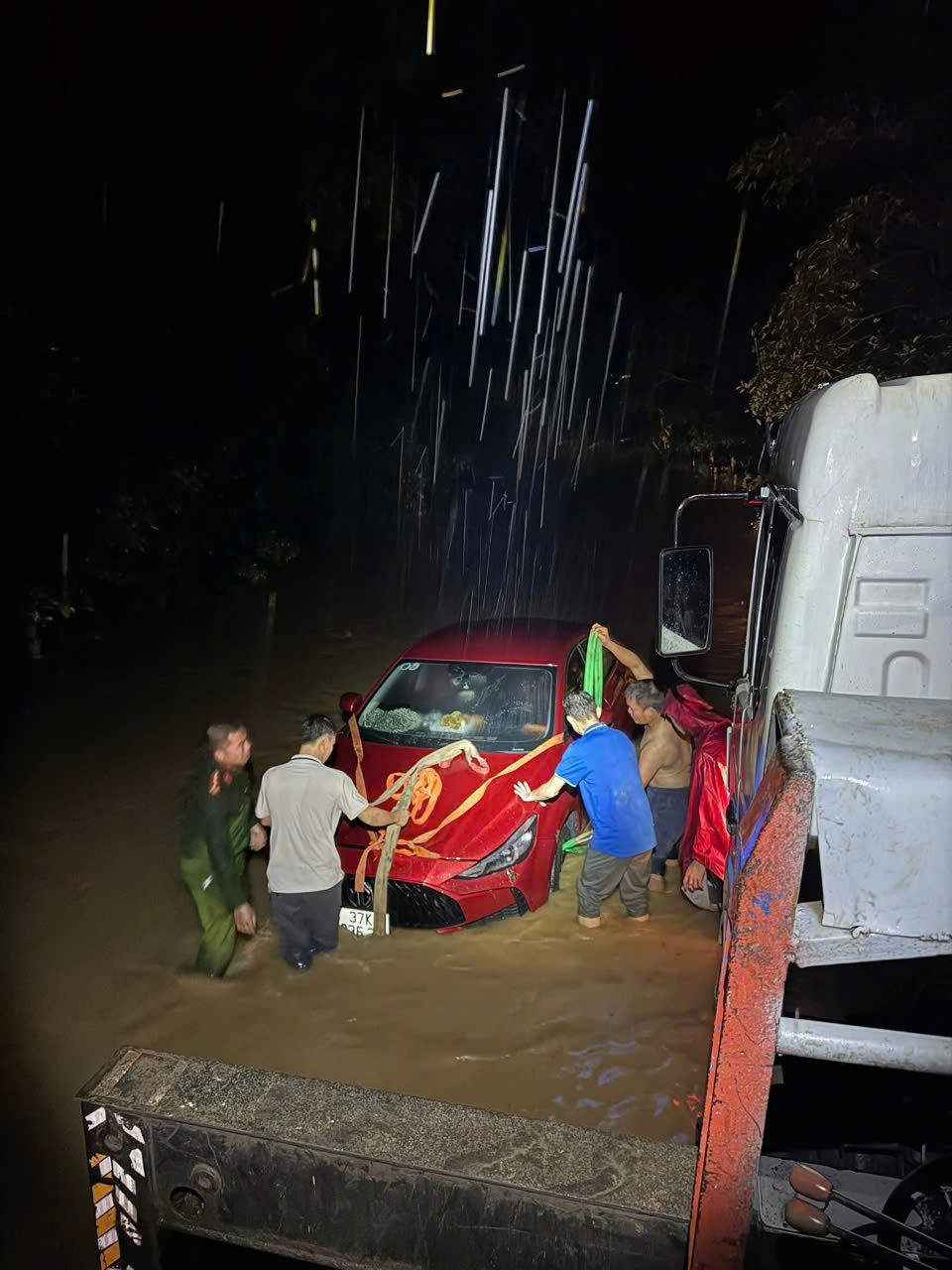 Công an xã Quỳ Châu cùng người dân đẩy xe ô tô bị ngập lụt