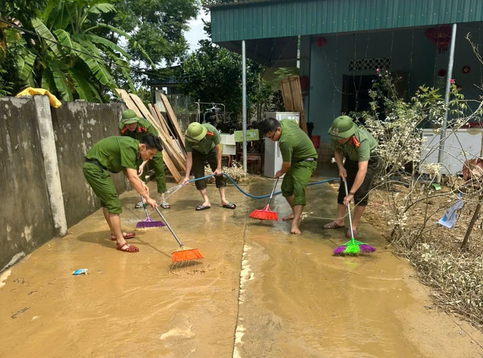 Công an xã Châu Bình giúp người dân dọn bùn đất, rửa sân