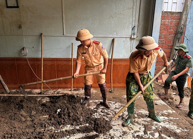 Cán bộ, chiến sĩ tổng dọn vệ sinh, nạo vét bùn đất ở nhà dân tại xã Mường Xén