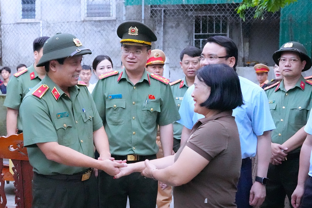 Thiếu tướng Nguyễn Hồng Nguyên, Phó Chánh Văn Phòng Bộ Công an động viên bà Nguyễn Thị Xuân - Hộ dân bị ảnh hưởng bởi cơn bão số 5