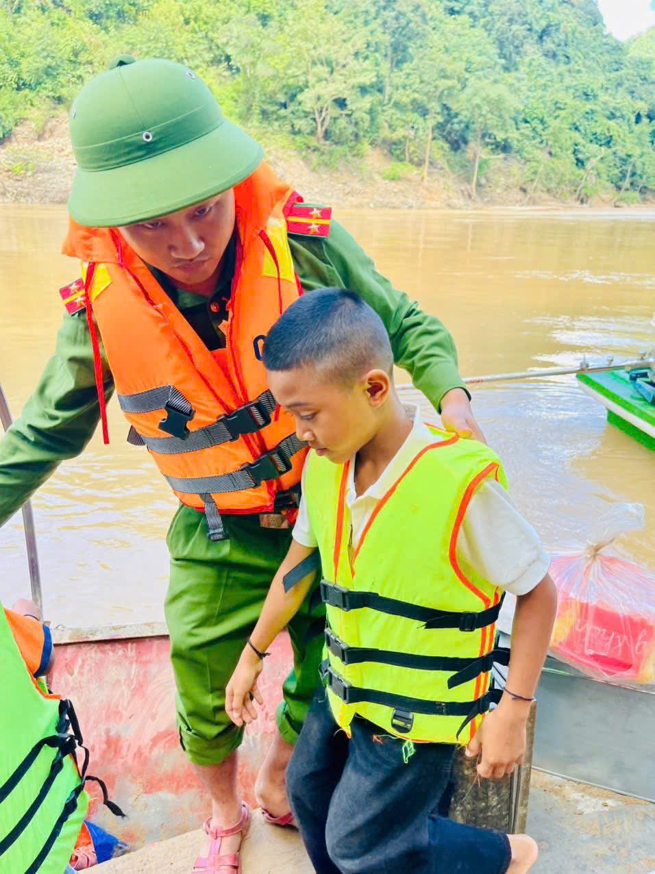 Cán bộ Công an xã Lượng Minh ân cần bố trí áo phao, chỗ ngồi cho các bạn nhỏ