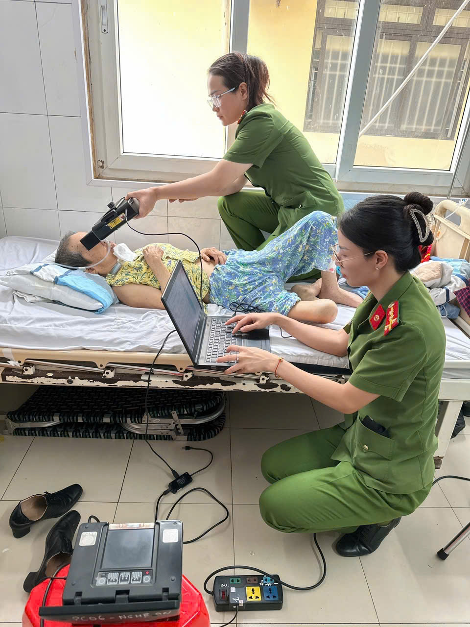 Cán bộ, chiến sỹ Phòng Cảnh sát QLHC về TTXH làm thủ tục cấp thẻ căn cước cho bà Phạm Thị Sửu bị tai nạn 7 năm không đi lại được và đang nằm điều trị tại khoa lây, Bệnh viện Hữu Nghị đa khoa Nghệ An 