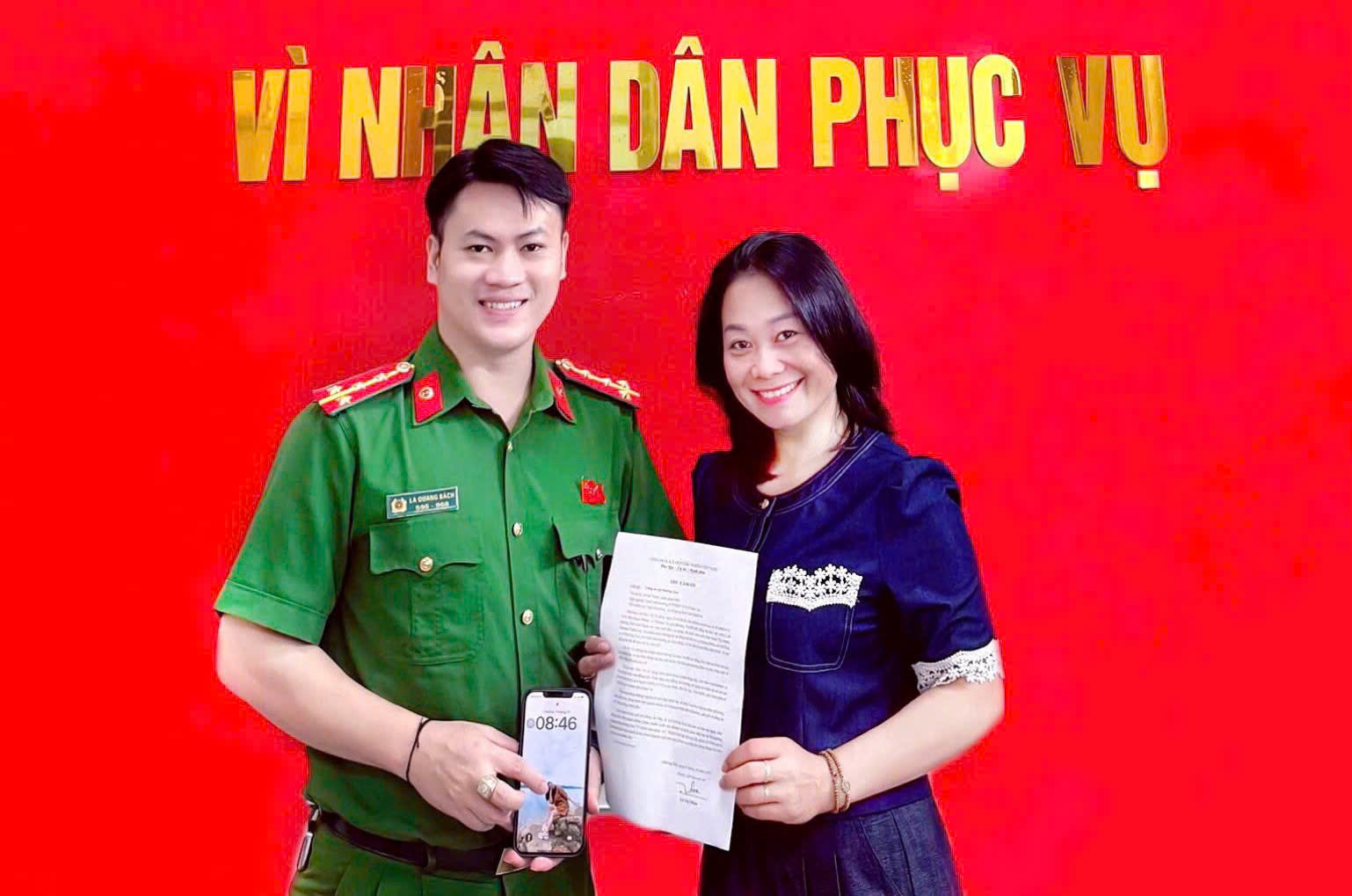 Đại úy La Quang Bách, cán bộ Công an xã Mường Xén trao trả điện thoại cho chị Lô Thị Thắm