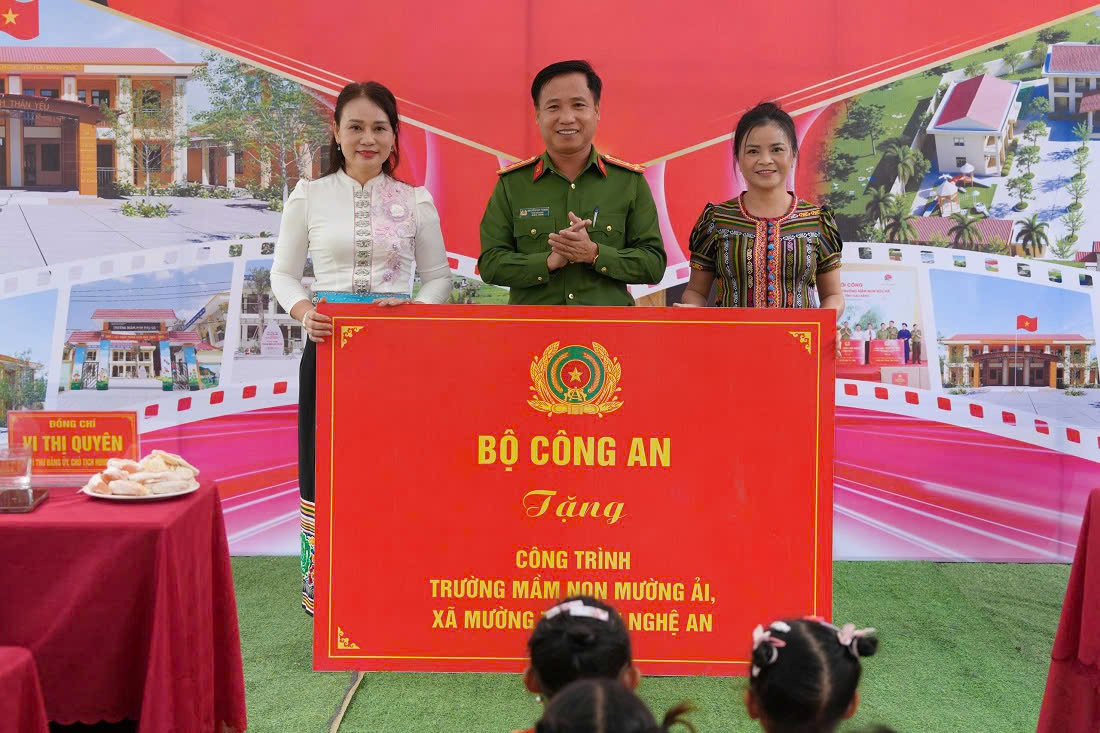 Các đại biểu dự buổi Thừa ủy quyền, đồng chí Đại tá Nguyễn Duy Thanh, Phó Giám đốc Công an tỉnh trao tặng bảng tượng trưng kinh phí xây dựng Trường Mầm non Mường Ải
