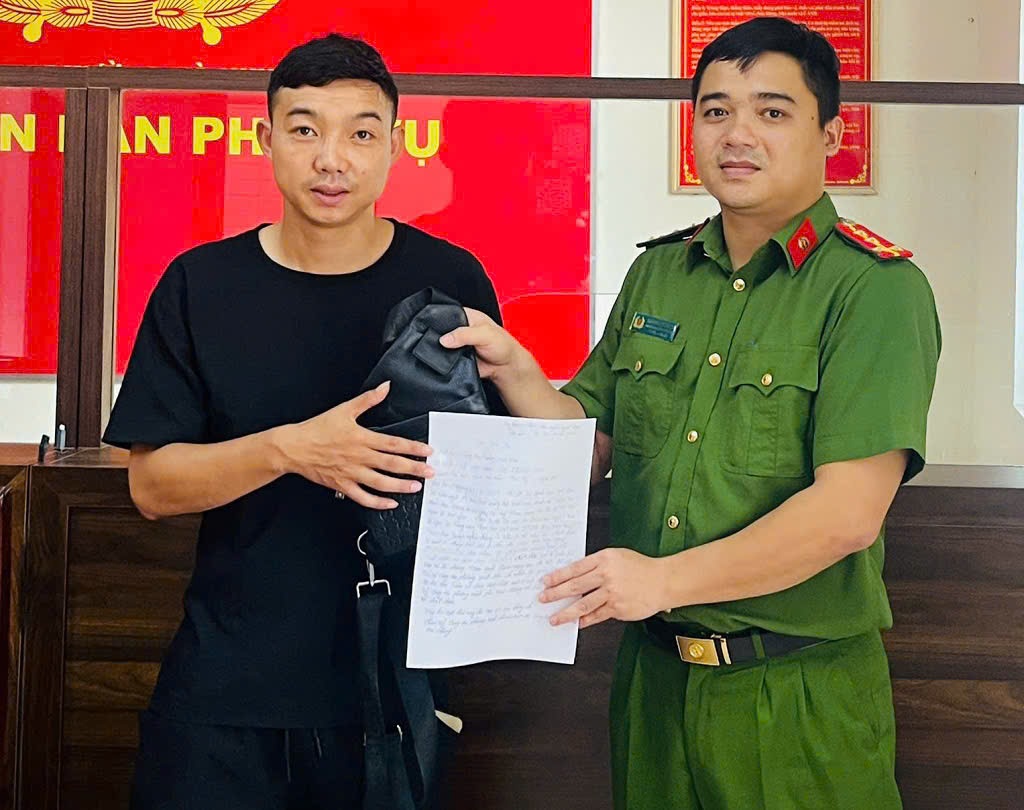 Đại úy Trần Nguyên Mạnh, cán bộ Công an phường Vinh Phú trao trả chiếc túi chứa 2.100 USD, 10.000 RUB (gần 60 triệu đồng Việt Nam) cho anh Lê Văn Công (sinh năm 1991), trú tại xã Tân Kỳ, tỉnh Nghệ An