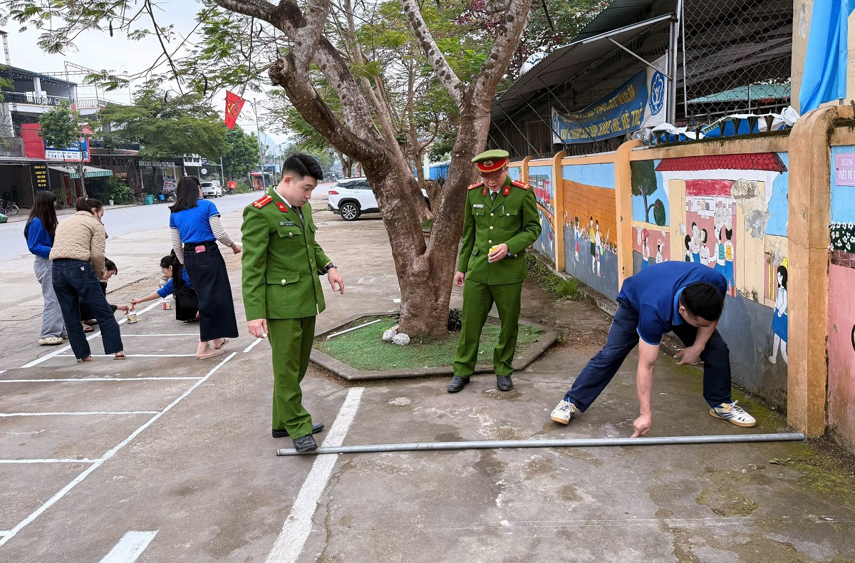 Công an xã Con Cuông phối hợp kẻ vạch quy chuẩn khu vực đỗ xe trước cổng trường tiểu học