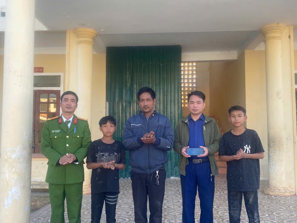 Công an xã và Ban Giám hiệu cùng 02 em học sinh Trường THCS Keng Đu trao trả điện thoại cho anh Phanh