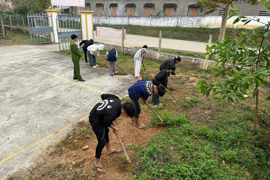 Các em học sinh tham gia lao động công ích dưới sự giám sát của cán bộ Công an
