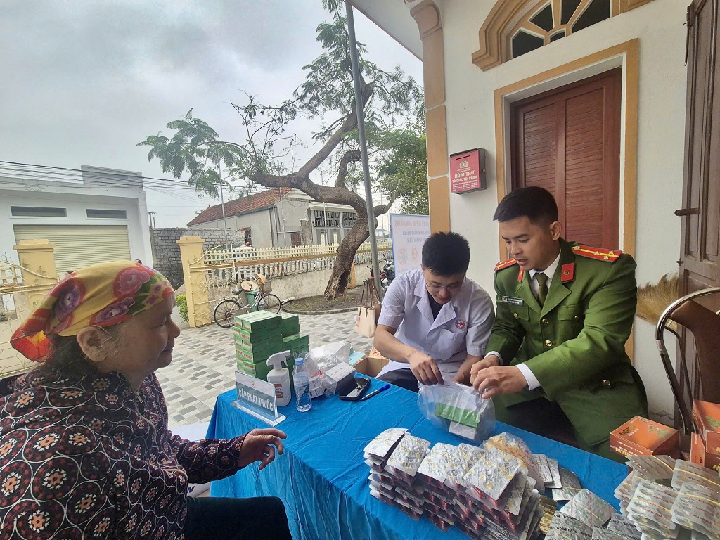 Công an xã hỗ trợ người dân nhận thuốc