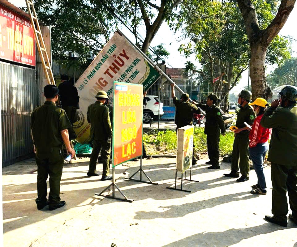 Lực lượng chức năng tháo dỡ mái che, biển quảng cáo lấn chiếm hành lang an toàn giao thông