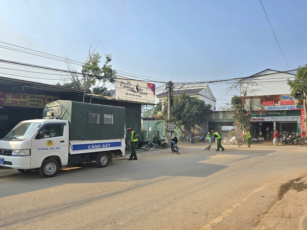 Công an xã Nghĩa Thọ dọn vật liệu xây dựng rơi vãi trên đường
