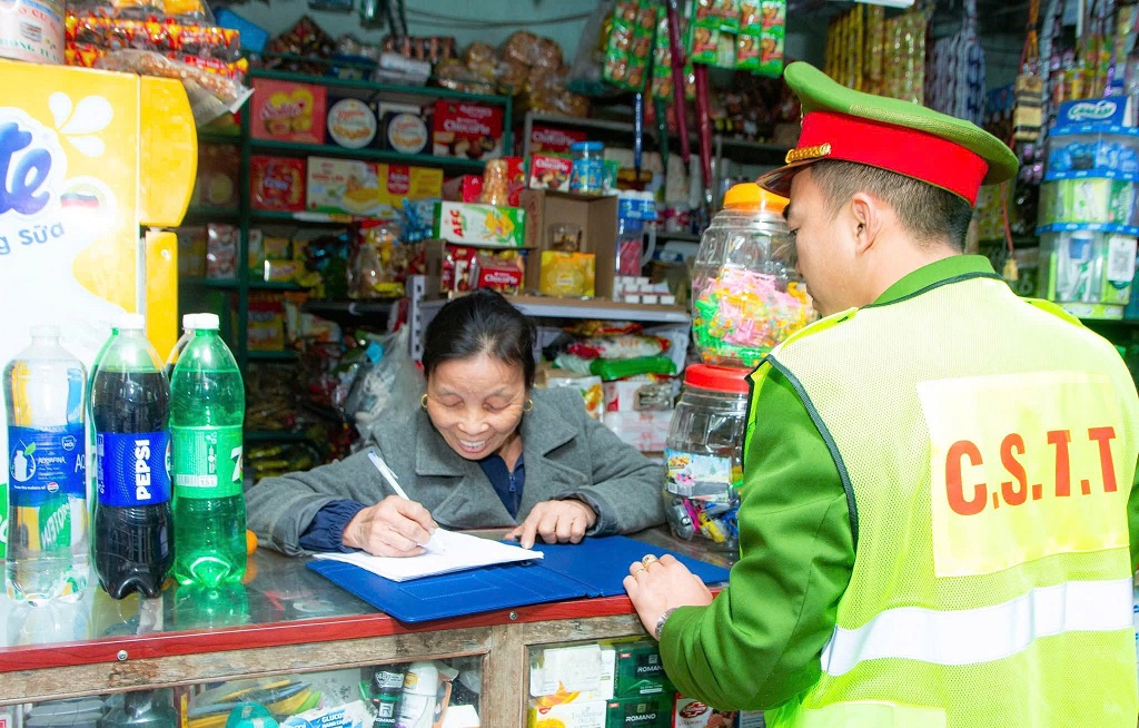 Công an xã hướng dẫn người dân ký cam kết không vi phạm TTATGT