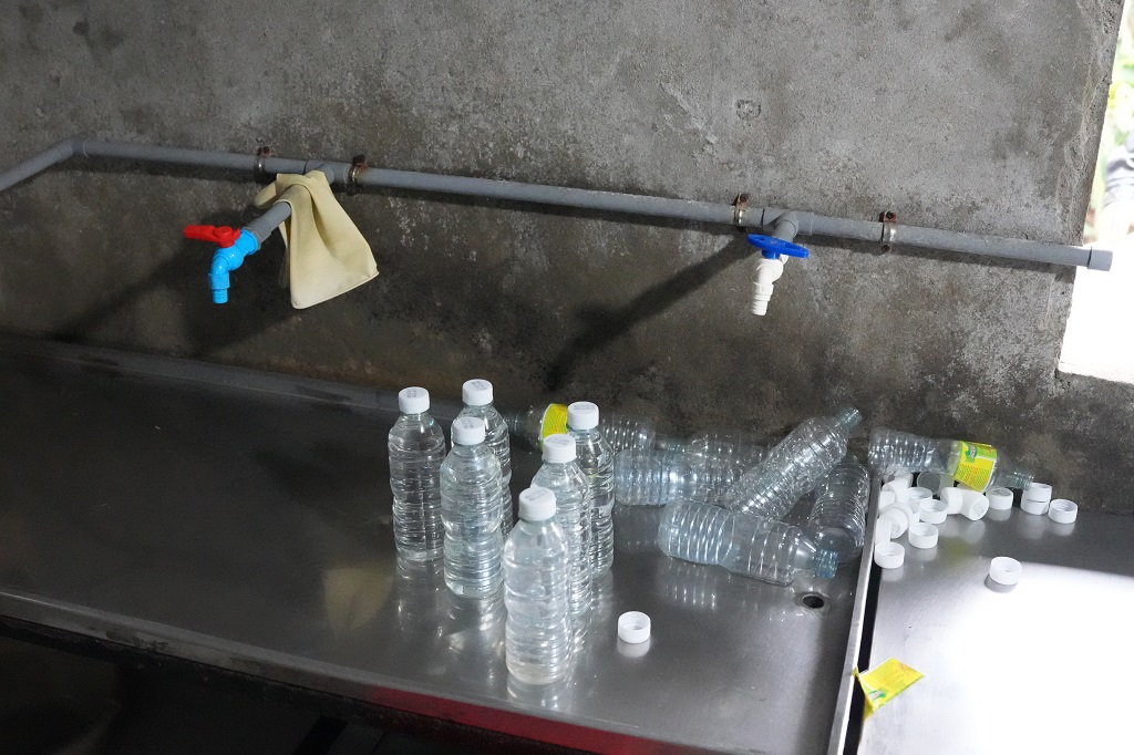 Sau khi pha chế axit acetic công nghiệp với nước lã, Lê Thị Lộc san chiết sang chai nhựa để tiêu thụ ra thị trường (Trong ảnh: Khu vực san chiết giấm giả tại cơ sở sản xuất của Lê Thị Lộc)