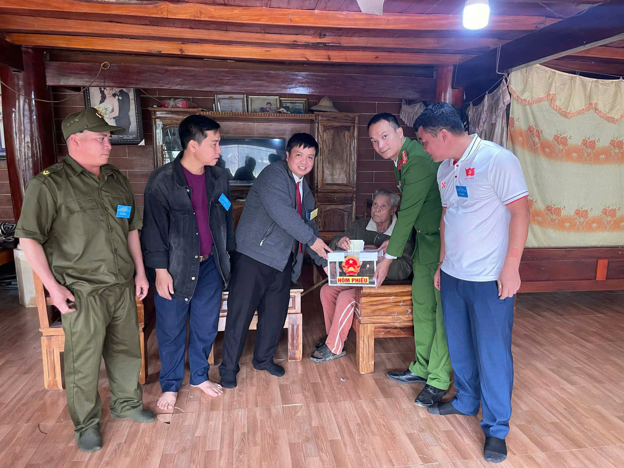 Công an xã Qùy Châu phối hợp mang thùng phiếu hỗ trợ người cao tuổi không đi lại được bỏ phiếu tại nhà 