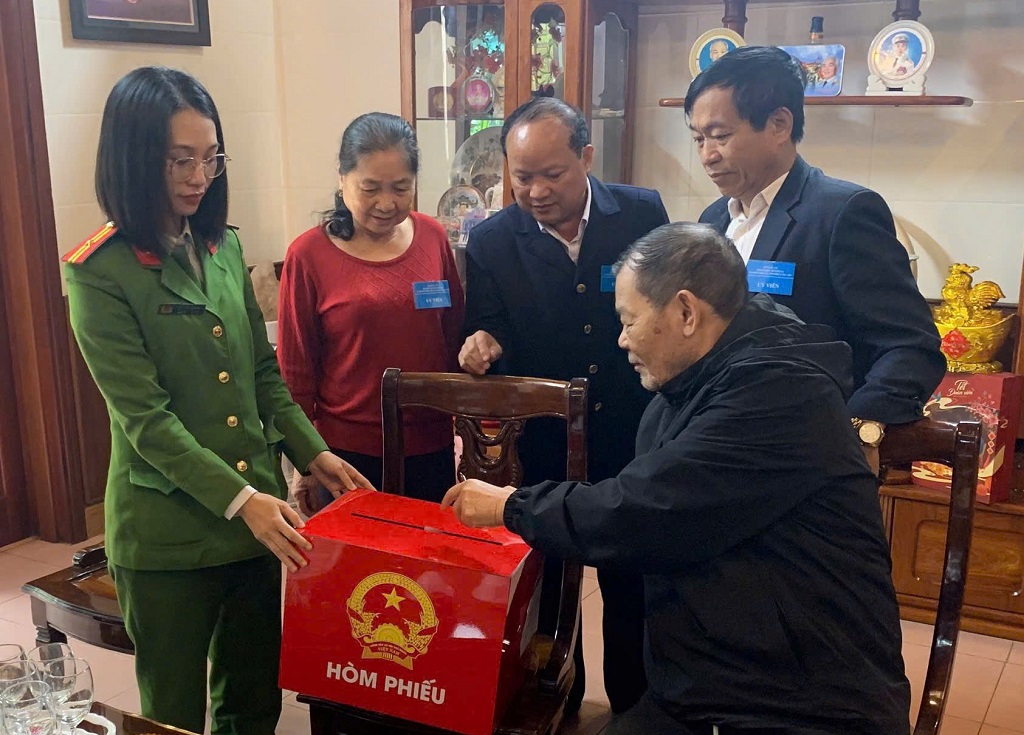 Công an phường Thành Vinh và thành viên tổ bầu cử đưa thùng phiếu lưu động đến tận nhà những cử tri cao tuổi, ốm đau 