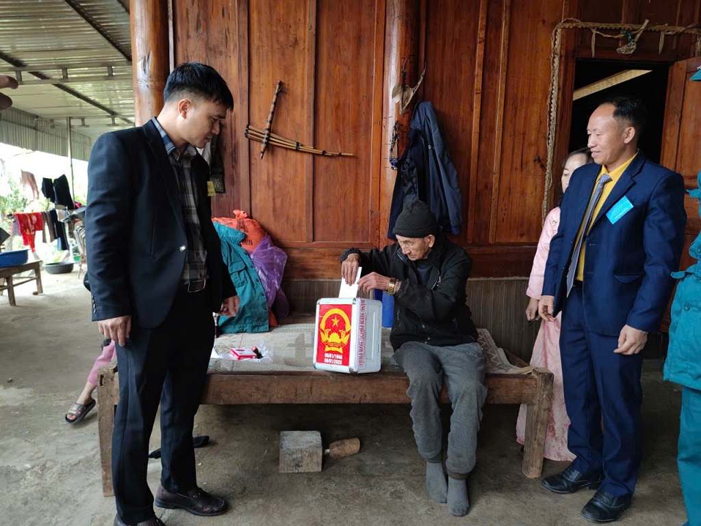 Tổ bầu cử xã Mường Xén mang thùng phiếu phụ, trực tiếp đến tận nhà cử tri 107 tuổi, hướng dẫn các bước bỏ phiếu theo đúng quy định của pháp luật, bảo đảm dân chủ, công khai và đúng trình tự