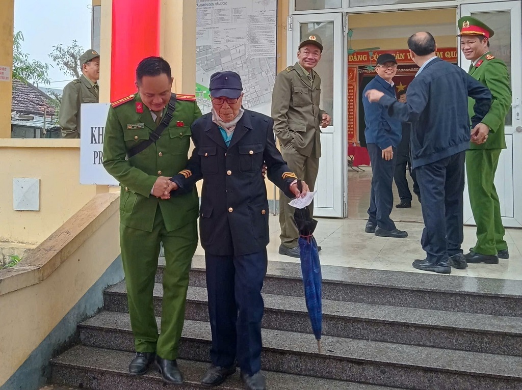 Công an phường Vinh Hưng hỗ trợ người già đến điểm bỏ phiếu