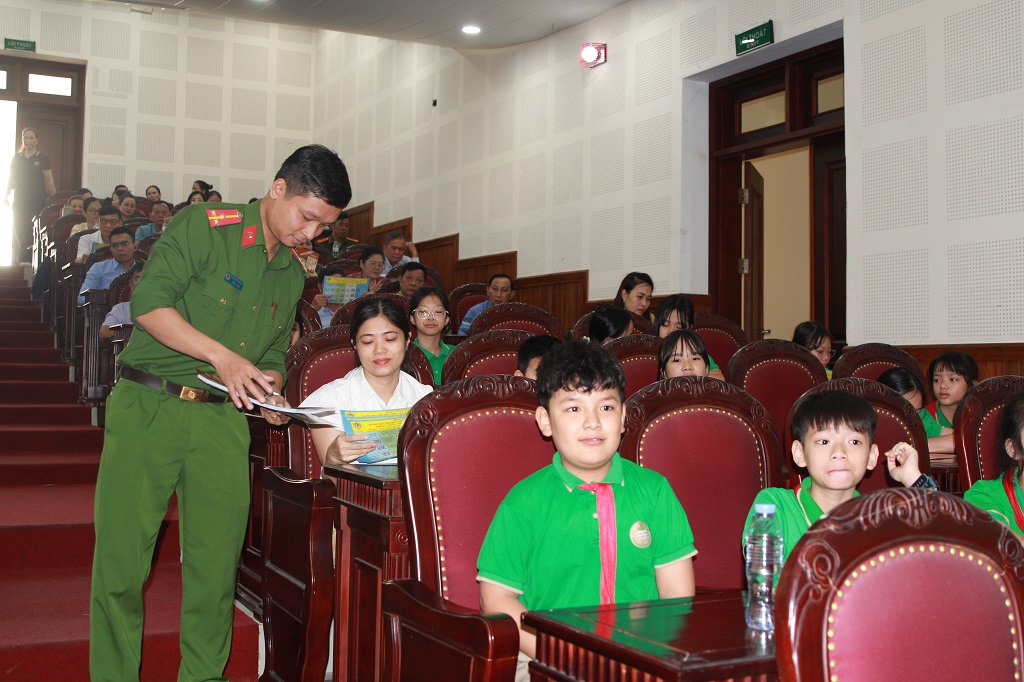 Tại buổi lễ, cán bộ Công an phường Thành Vinh phát tờ rơi tới học sinh, phụ huynh về kiến thức phòng cháy, chữa cháy và cứu nạn, cứu hộ