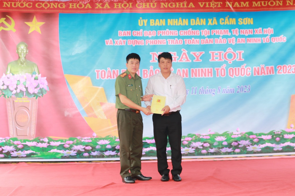 Đồng chí Đại tá Trần Hồng Quang, Phó Giám đốc Công an tỉnh tặng quà cho đại diện cấp ủy, chính quyền UBND xã Cẩm Sơn, huyện Anh Sơn