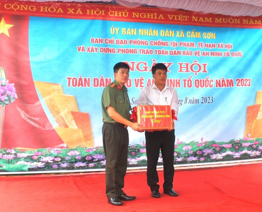 Đồng chí Đại tá Trần Hồng Quang, Phó Giám đốc Công an tỉnh trao tặng quà của tỉnh cho UBND xã Cẩm Sơn