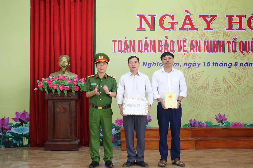 Đồng chí Đại tá Trần Ngọc Tuấn, Phó Giám đốc Công an tỉnh tặng quà cấp ủy, chính quyền xã Nghĩa Lâm