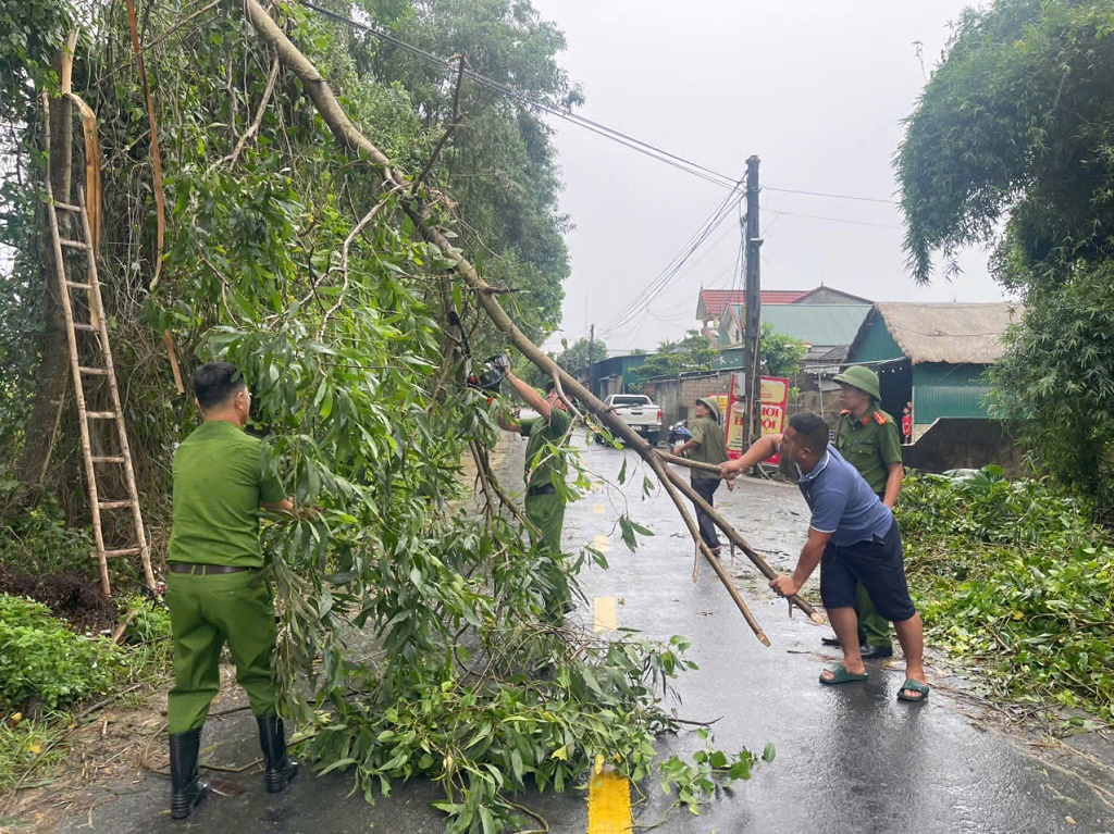 Công an xã cùng người dân chặt, dọn các cây bị gãy, ngã ra đường do gió quật, kịp thời mở lối đi an toàn cho các phương tiện và người qua lại	