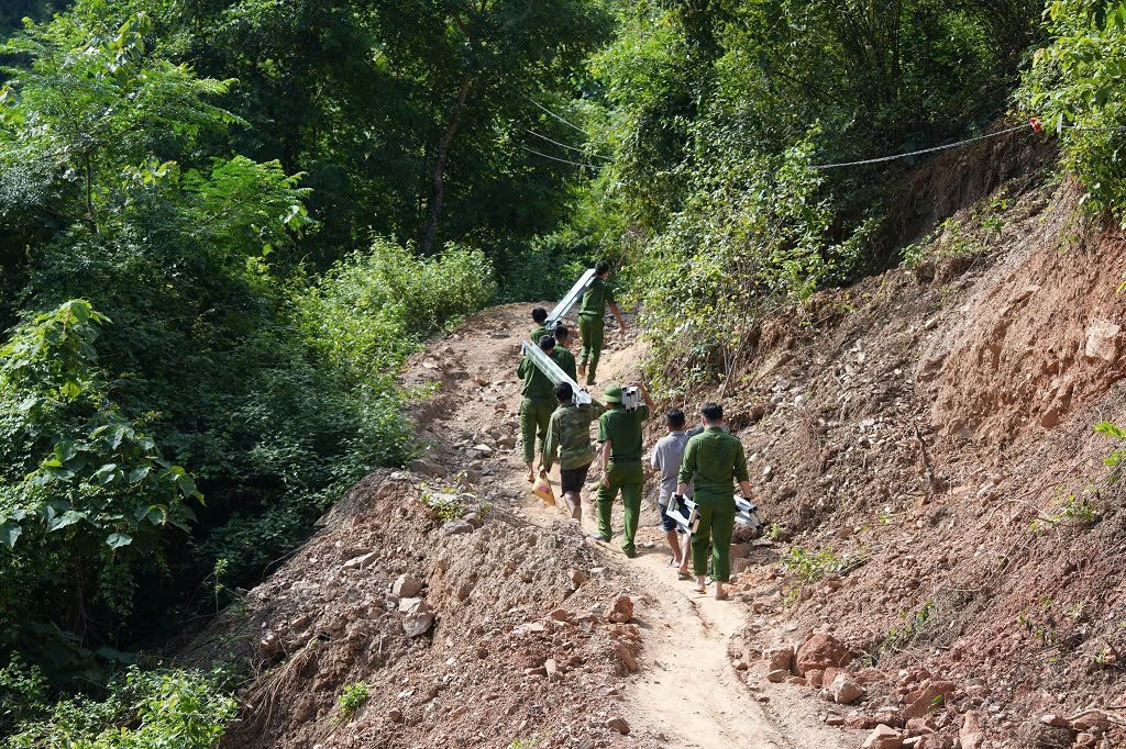 Công an xã Mường Xén vận chuyển vật liệu lên đồi để dựng nhà cho hộ gia đình anh Lữ Văn Liêng