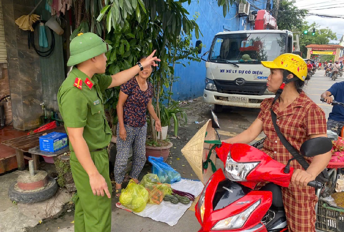 Công an xã nhắc nhở người dân không lấn chiếm lòng, lề đường để buôn bán