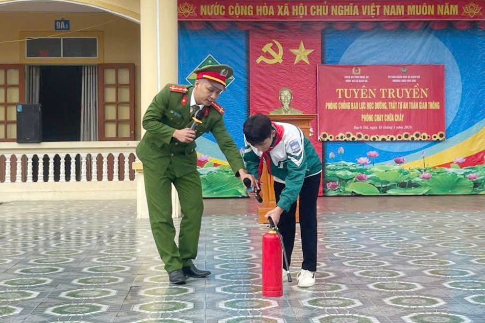 Công an xã hướng dẫn học sinh sử dụng bình chữa cháy