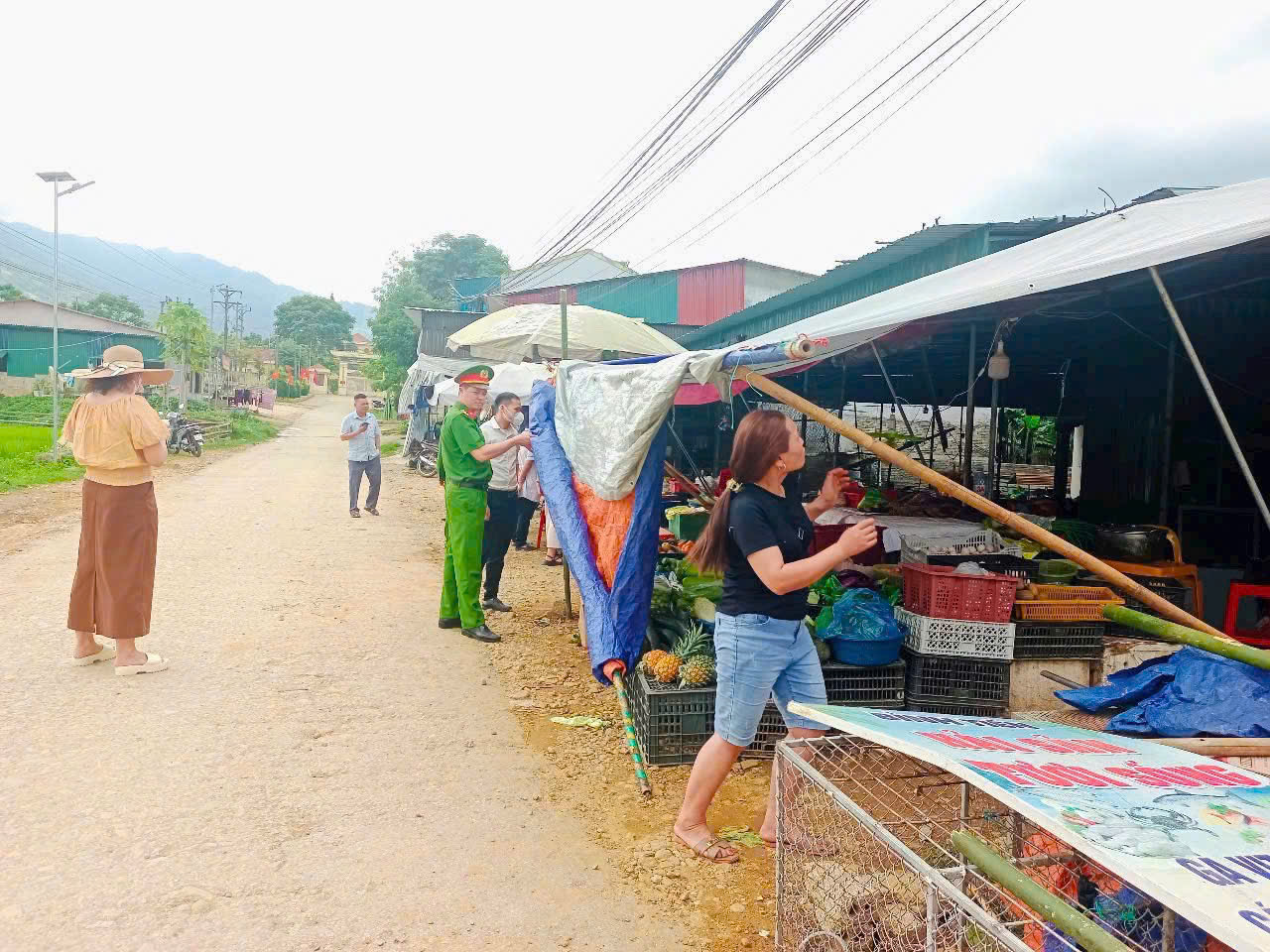 Công an xã nhắc nhở người dân không buôn bán lấn chiếm hành lang an toàn giao thông