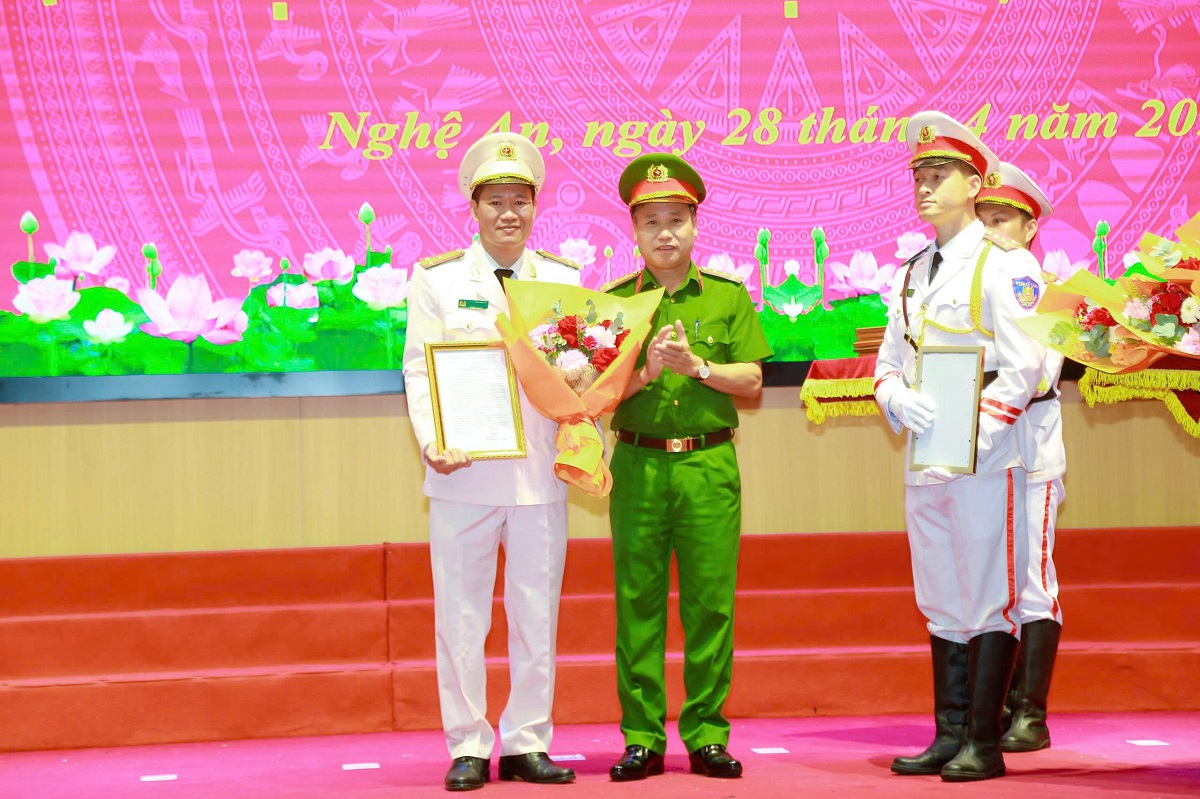 Đồng chí Đại tá Nguyễn Duy Thanh, Phó Giám đốc Công an tỉnh trao quyết định, tặng hoa chúc mừng các đồng chí được thăng cấp bậc hàm Thượng tá