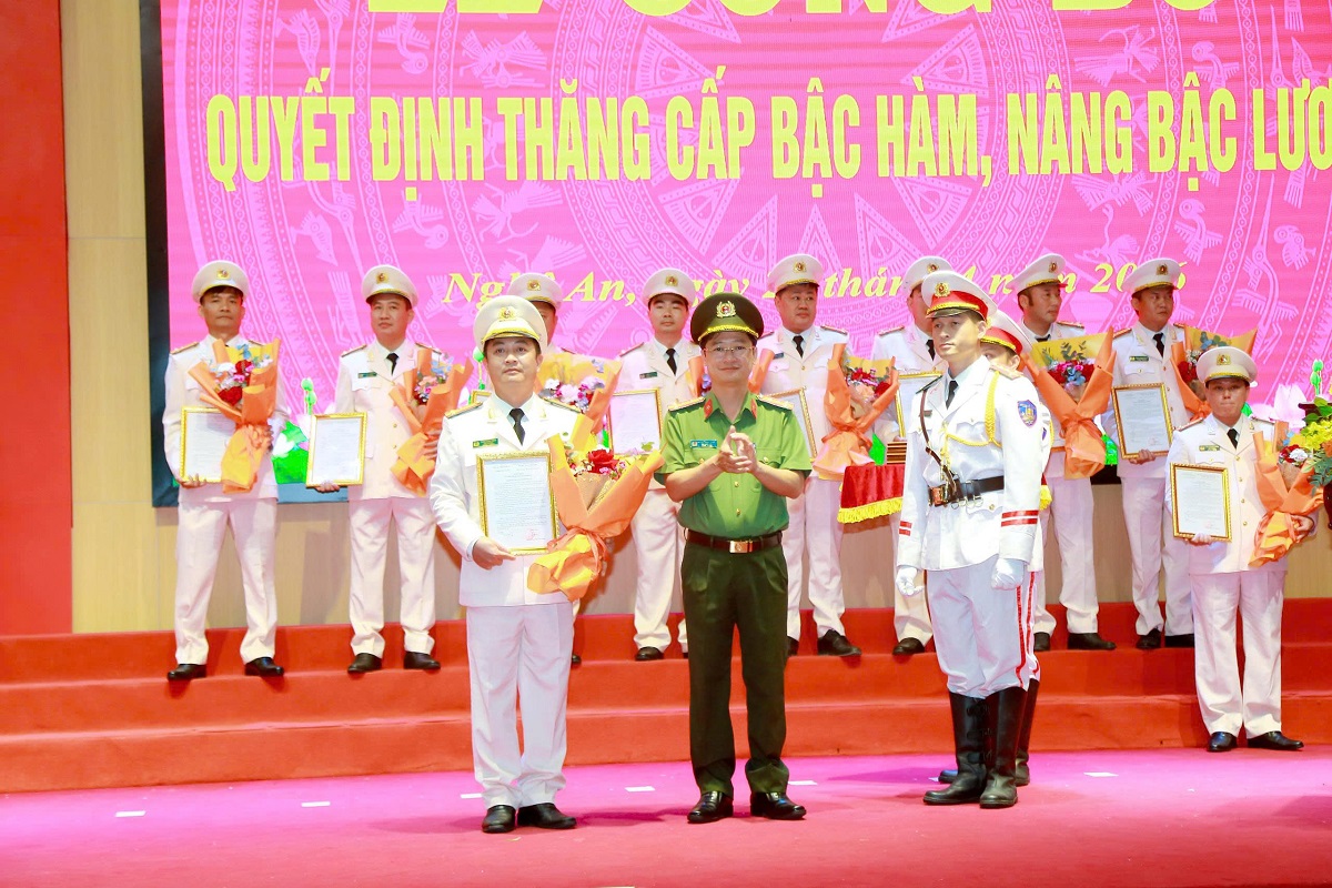 Đồng chí Đại tá Trần Ngọc Tuấn, Phó Giám đốc Công an tỉnh trao quyết định, tặng hoa chúc mừng các đồng chí được thăng cấp bậc hàm Thượng tá