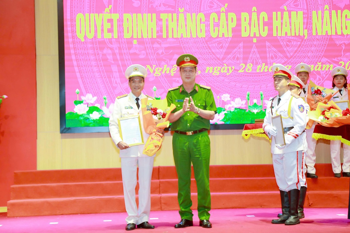 Đồng chí Đại tá Nguyễn Đức Cường, Phó Giám đốc Công an tỉnh trao quyết định, tặng hoa chúc mừng các đồng chí được thăng cấp bậc hàm Thượng tá