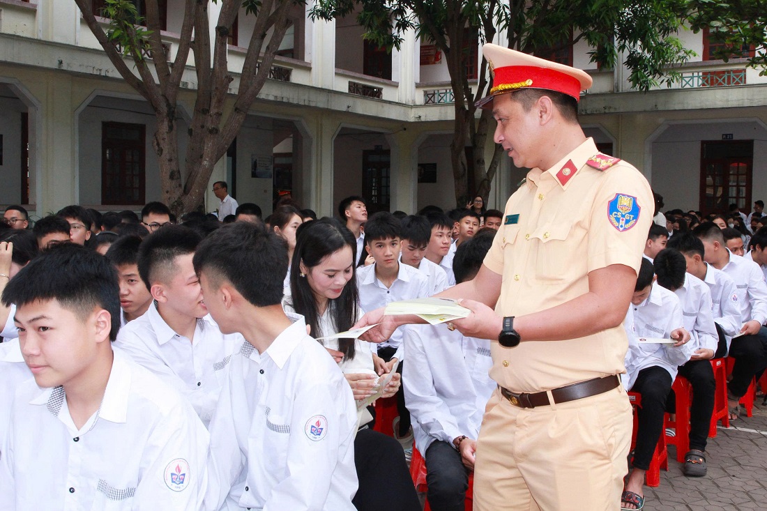 Đại diện Cục CSGT và Phòng CSGT tặng tờ rơi và bút gắn logo tuyên truyền pháp luật về trật tự an toàn giao thông đến học sinh