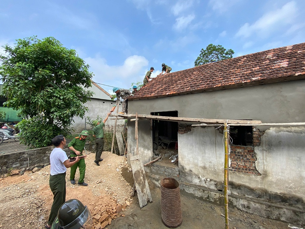 Công an xã cùng lực lượng an ninh trật tự cơ sở vận chuyển vật liệu, sửa chữa mái nhà cho người dân
