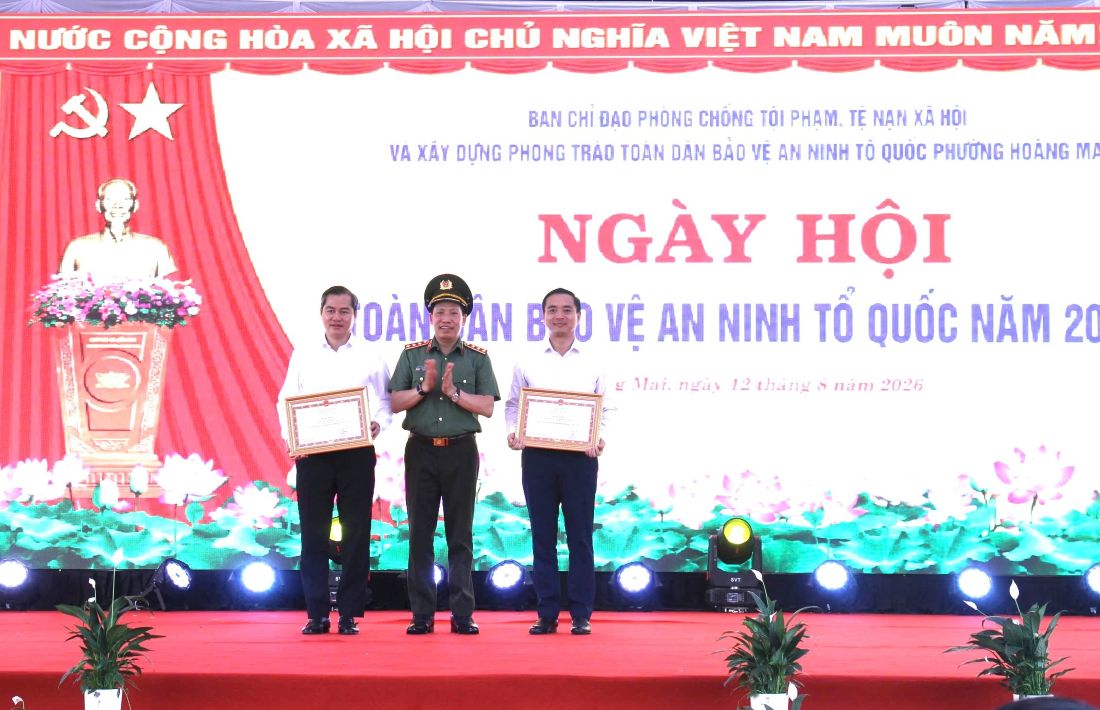 Đồng chí Thượng tướng Lê Văn Tuyến - Ủy viên Ban Chấp hành Trung ương Đảng, Thứ trưởng Bộ Công an, Trưởng Ban Chỉ đạo thực hiện phong trào bảo vệ ANTQ Trung ương trao Bằng khen của Bộ trưởng Bộ Công an tặng Nhân dân, cán bộ phường Vinh Phú và đồng chí Nguyễn Hữu An - Bí thư Đảng ủy phường Hoàng Mai