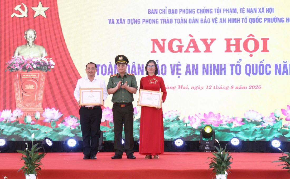 Đồng chí Thiếu tướng Đinh Việt Dũng, Ủy viên Ban Thường vụ Tỉnh ủy, Bí thư Đảng ủy, Giám đốc Công an tỉnh trao Giấy khen của Giám đốc Công an tỉnh tặng Trường THPT Hoàng Mai và ông Phạm Văn Hào - Chủ tịch UBND phường Hoàng Mai