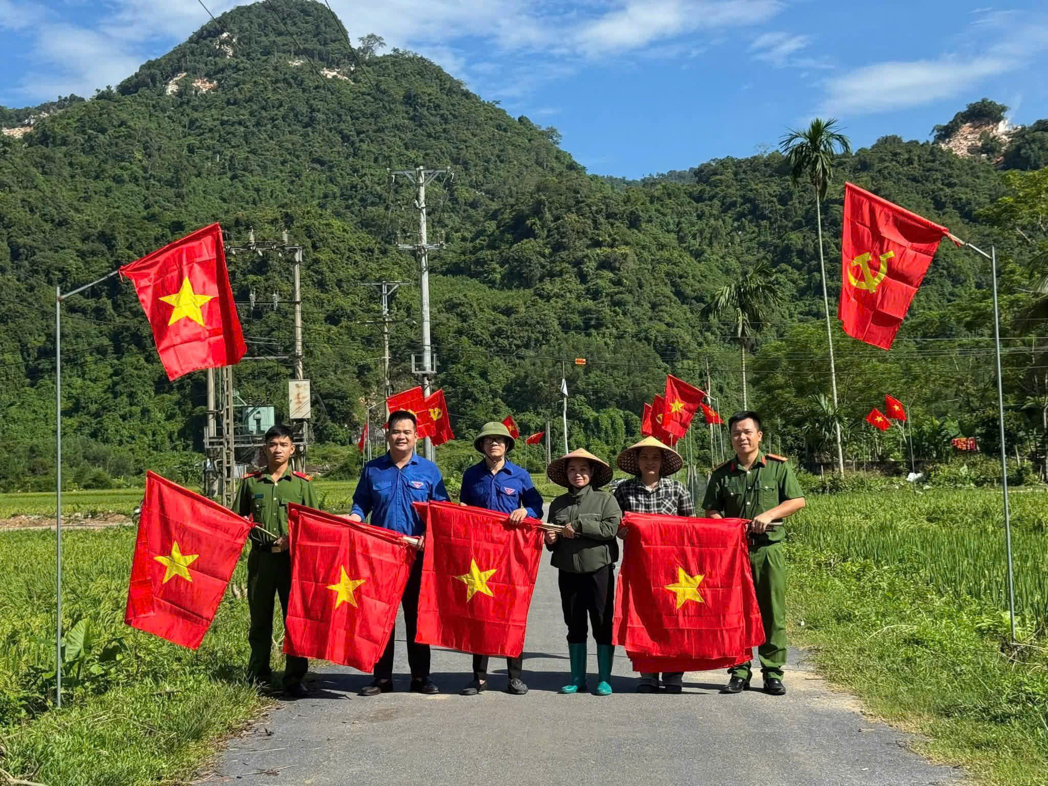 Công an xã cùng Nhân dân cắm cờ trên các tuyến đường