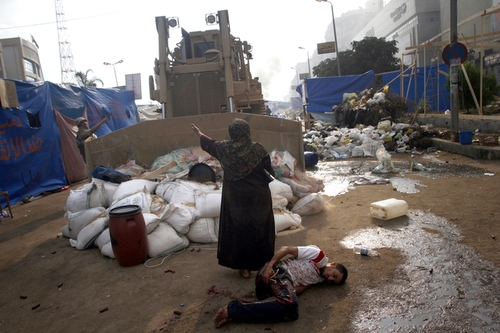A woman tried to stop a military bulldozer from hurting a wounded man during clashes near Raba'a al Adiwiya mosque in eastern Cairo.